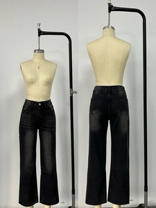Dettaglio dei jeans larghi grigio scuro con baffature slavate sul davanti e sul retro