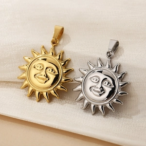 Detail showing polished gold and silver celestial sun face pendants on silk fabric
