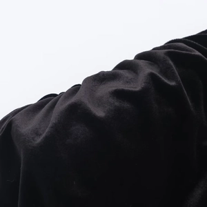 Close-up of premium black velvet fabric showing soft texture and elegant fold details