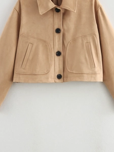 Detail of camel suede cropped jacket with large front pockets and black button closure
