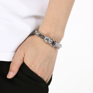 Close-up of a men's titanium steel bracelet with double wolf head design and magnetic clasp