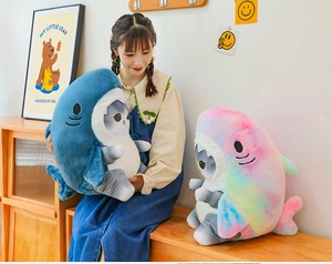 Detail of plush shark cat doll showing soft blue and rainbow texture in home setting