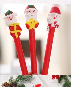 Close-up of cute Santa Claus figurine pens with stars and candy canes on a festive desk
