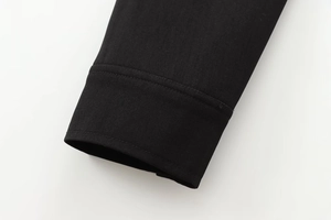 Detail of black twill fabric sleeve cuff on a minimalist stand collar bomber jacket