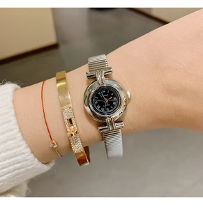 Close-up of DINIMI women's quartz watch with silver round case and Roman numerals