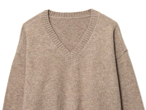 Détail du pull en tricot doux à col en V couleur avoine avec col côtelé et coutures