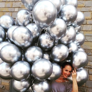 Bunch of shiny silver metallic balloons tied with ribbons for festive party decoration