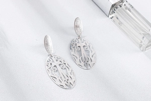Détails des boucles d'oreilles évidées en argent avec motifs d'épées et fleurs ciselées