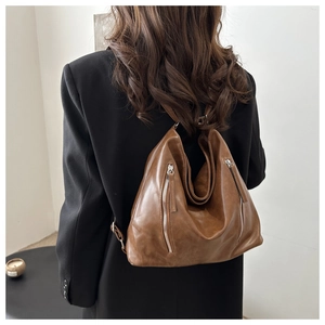 Dettaglio della borsa tote in ecopelle marrone con due tasche verticali con cerniera da donna
