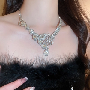 Detail of silver drop pendant necklace with sparkling diamonds on a female model