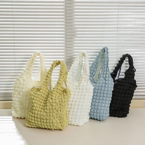 Close-up of popcorn texture fabric on tote bags in multiple pastel colors and white