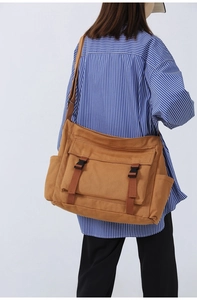 Sac bandoulière en toile marron avec rabat et boucles doubles vue de dos sur un mannequin