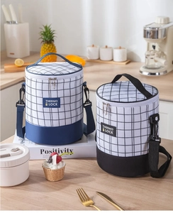 Insulated cylindrical lunch bags in plaid patterns with adjustable shoulder straps