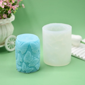 Embossed butterfly cylindrical silicone mold and blue candle with floral display