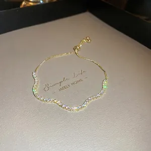 Adjustable wavy gold bracelet with pave-set crystals on elegant leather display