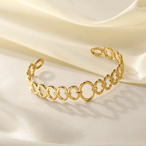 Detailed shot of interlocking oval links on a gold-plated open cuff bracelet