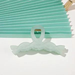 Close-up of translucent mint green matte hair claw clip with golden metal spring