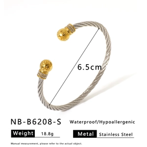 Detail of twisted steel cable bracelet with gold hammered finish and zircon inlays