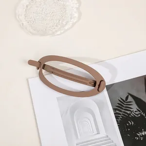 Detail of large matte brown oval hair claw clip with frosted texture and hollow design