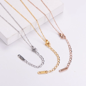 Detailed view of silver, gold, and rose gold cross chains with lobster clasps and 18KGP tags