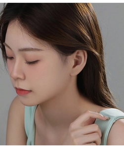 Close-up of S925 sterling silver hollow butterfly stud earrings worn by a model