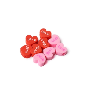 Macro shot of red and pink heart polymer clay beads with LOVE print for DIY jewelry making