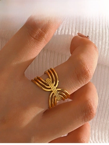 Detailed macro view of a gold multi-layer woven hollow ring worn on a finger