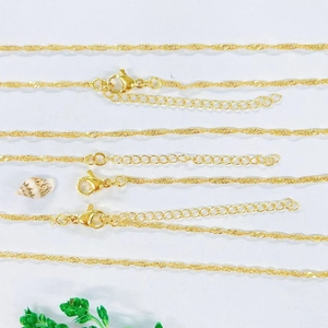 Selection of gold-plated copper necklaces with various chain styles on white background