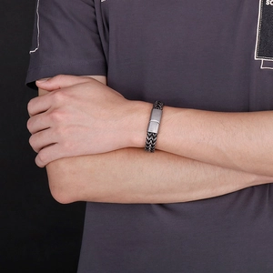 Detail of men's black woven keel bracelet with silver frosted stainless steel magnetic clasp