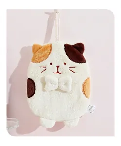 Detail of cute cat shaped hand towel in beige plush with soft hanging loop for kitchen