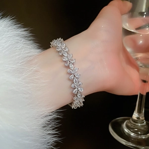 Gros plan d'un élégant bracelet fleur en argent avec pierres marquises sur le poignet
