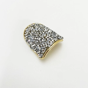 Close-up of golden fan-shaped hair clip with sparkling rhinestones on white background