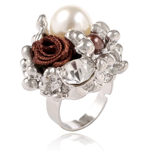Détail d'une bague fleur avec perle blanche, rose en tissu marron et cristaux scintillants