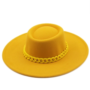Detail of a bright yellow wool fedora featuring a stylish matte chain link decoration
