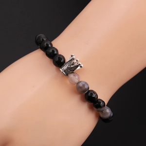 Detail of 8mm faceted black and grey beaded crown bracelet on a model's wrist