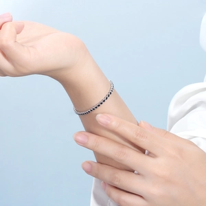 Detailed view of S925 sterling silver tennis bracelet with black cubic zirconia on wrist