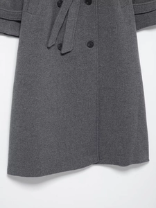 Detailed view of dark grey wool coat featuring button closure and matching waist belt