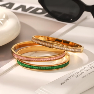 Three gold bangles with colorful zircon stones styled with fashion accessories