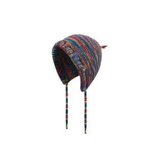 Macro detail of rainbow striped knit beanie showing colorful yarn texture and earflaps