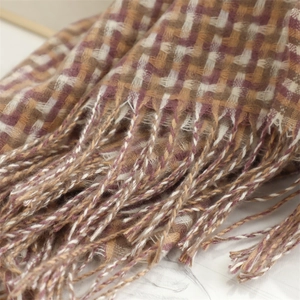 Detailed view of the woven plaid texture and soft fringe on this winter cashmere shawl