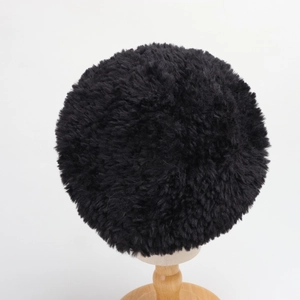 Detailed texture of a black plush faux rabbit fur beret hat on a wooden stand
