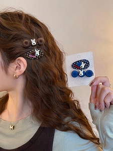 Detail view of plush puppy hair clips with Zsiga cartoon design and polka dot patterns