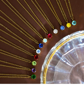 Golden stainless steel necklaces with various colorful birthstone pendants in fanned layout
