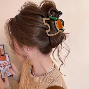 Detail of colorful geometric resin hair claw clip with vintage patchwork style on hair