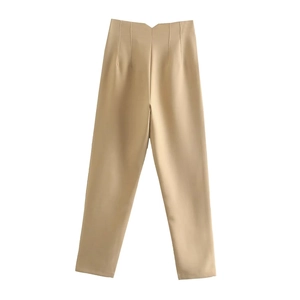 Detail of high-waist trousers in light khaki with minimalist V-cut waistline design