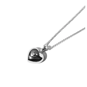 Close-up of polished silver heart pendant necklace with metallic luster on white background