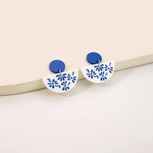 Detail of blue and white porcelain pattern earrings with geometric acrylic elements