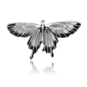 Retro butterfly alloy brooch with black and white enamel finish on a white reflective base