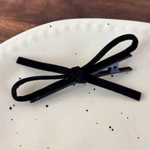 Close-up of a black velvet bow hair clip with a durable metal duckbill clip