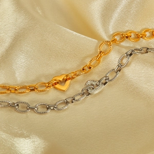 Detail of heart pendants in gold and silver finishes on elegant satin fabric